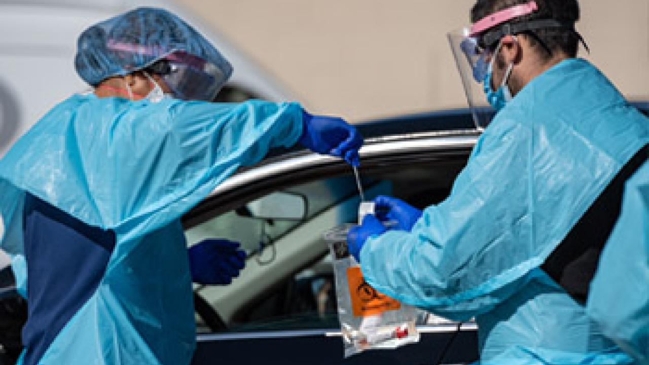 UC Davis Health clinicians conduct COVID-19 tests at a drive-through testing site. clinicians conduct COVID-19 tests at a drive-through testing site
